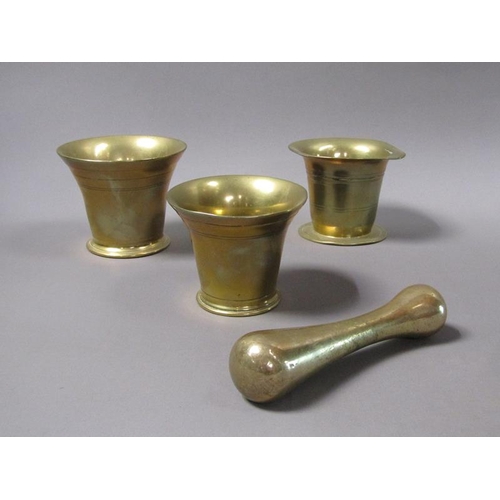 54 - A late 18c/early 19c bronze mortars and a pestle, the mortars, 12.5cm, 13cm & 14cm diam mouths, and ... 