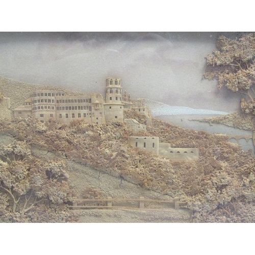 57 - A 19c cork picture of a monastery on a timbered hillside close to a river estuary, framed and glazed... 