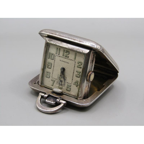 73 - A small Swiss travelling clock in folding silver case made by Sapho and retailed by Elkingtons.  The... 