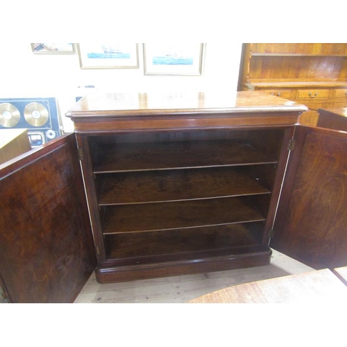 1489 - VICTORIAN FIGURED MAHOGANY SIDE CABINET WITH FITTED SHELVES ENCLOSED BY TWO PANEL DOORS ON MOULDED P... 