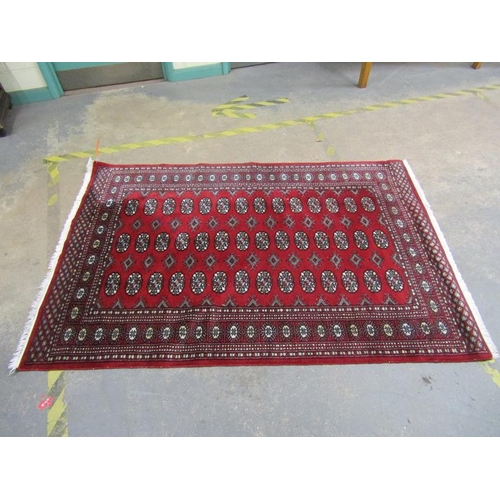 1984 - ORIENTAL WOOLLEN RED GROUND PATTERNED RUG 129 x 197 cms