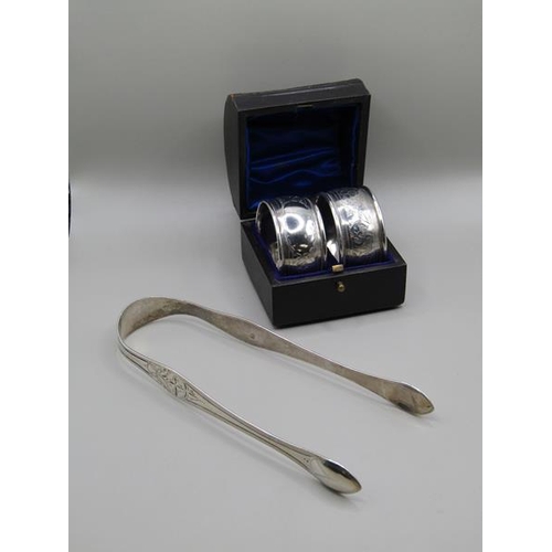 1554 - TWO BOXED SILVER NAPKINS AND A SET OF SILVER SUGAR TONGS