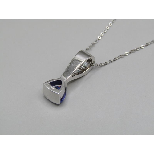 1594 - A tanzanite and baguette diamond 14ct white gold pendant on a 18ct white gold chain.