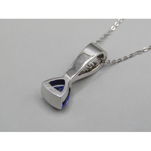 1594 - A tanzanite and baguette diamond 14ct white gold pendant on a 18ct white gold chain.