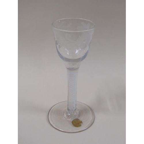 1868 - A mid 18c wine glass with ogee bowl, engraved with a border of leaf and flowers, the stem with white... 