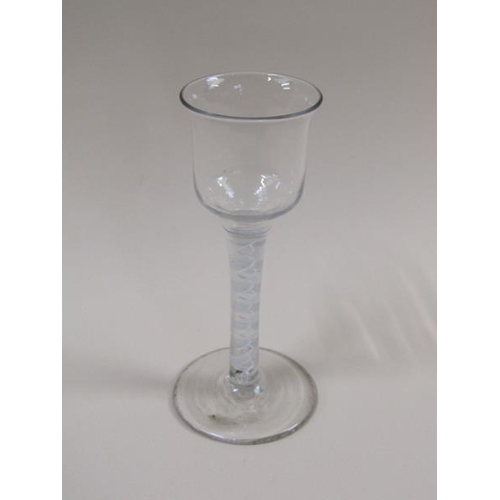 1874 - A mid 18c wine glass with a round funnel bowl on a twelve ply spiral with a pair of spirals tapes on... 