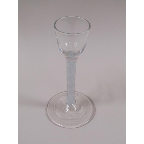 1876 - A mid 18c cordial glass with a round funnel bowl on a fifteen ply spiral band outside a spiral tape ... 