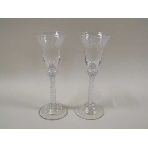 1879 - A pair of 18c wine glasses, the bell shaped bowls engraved with borders of fruiting vine.  The stems... 