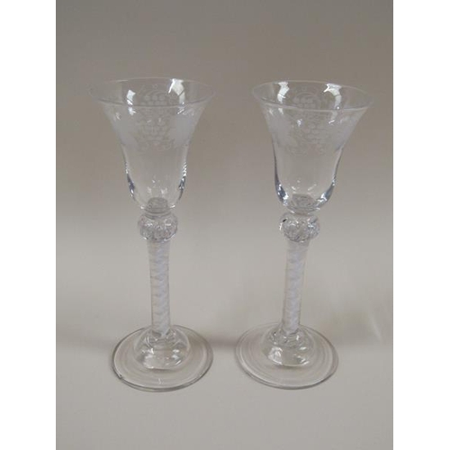 1879 - A pair of 18c wine glasses, the bell shaped bowls engraved with borders of fruiting vine.  The stems... 