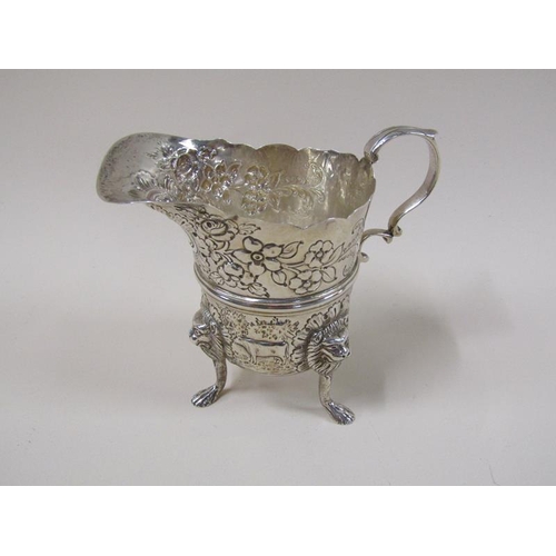 1745 - An Irish silver cream jug with wide pouring spout, later embossed and chased floral decoration, the ... 