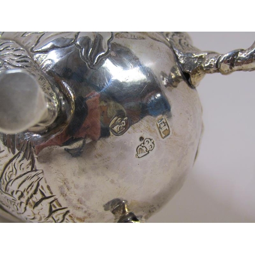 1746 - An 18c silver cream jug, embossed and chased with scroll, leaf and flowers, the base with a milkmaid... 