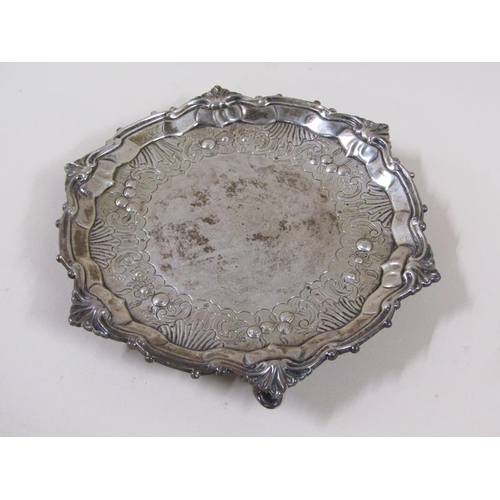 1755 - A late 18c salver of circular form on three legs, having a raised shaped border, assay marks rubbed,... 