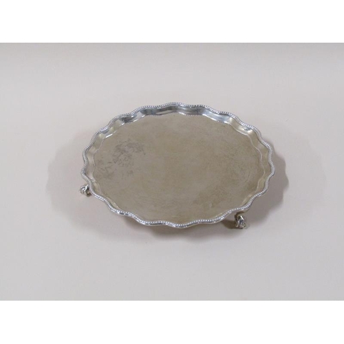 1758 - A late Georgian silver salver of circular form with a shaped raised and beaded border supported on t... 