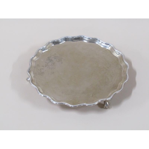 1758 - A late Georgian silver salver of circular form with a shaped raised and beaded border supported on t... 