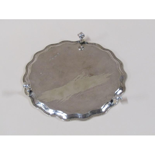 1758 - A late Georgian silver salver of circular form with a shaped raised and beaded border supported on t... 