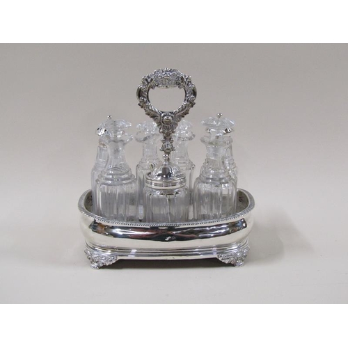 1767 - An early 19c silver frame condiment stand with seven cut bottles and stoppers, three with silver cov... 