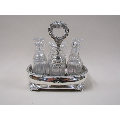 1767 - An early 19c silver frame condiment stand with seven cut bottles and stoppers, three with silver cov... 