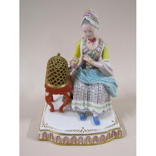 1967 - A pair of Meissen porcelain figure groups - girl seated feeding bird in cage & lady seated with dres... 