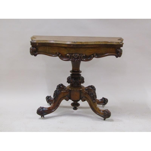 2042 - A mid Victorian burr walnut fold over serpentine card table with a scroll and floral carved frieze, ... 