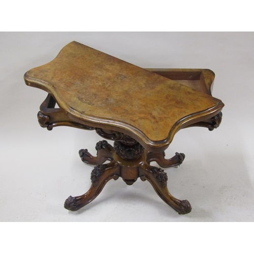 2042 - A mid Victorian burr walnut fold over serpentine card table with a scroll and floral carved frieze, ... 