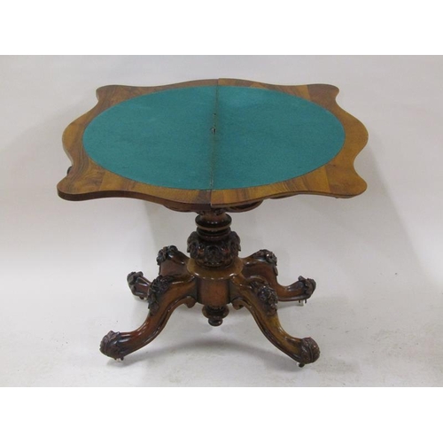 2042 - A mid Victorian burr walnut fold over serpentine card table with a scroll and floral carved frieze, ... 