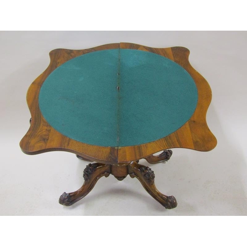 2042 - A mid Victorian burr walnut fold over serpentine card table with a scroll and floral carved frieze, ... 