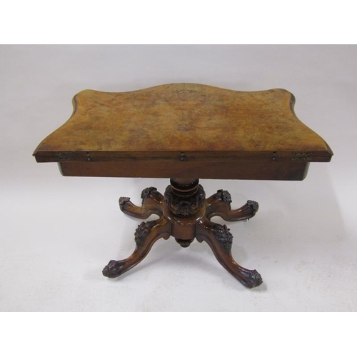 2042 - A mid Victorian burr walnut fold over serpentine card table with a scroll and floral carved frieze, ... 