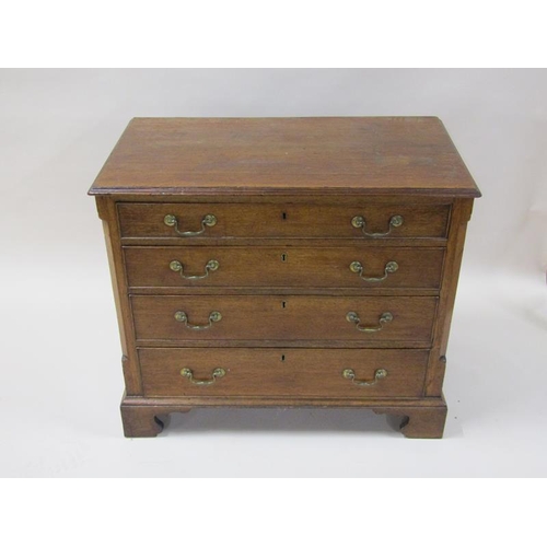 2045 - A George III oak chest of four long graduated drawers with encanted corners, the top with moulded ed... 