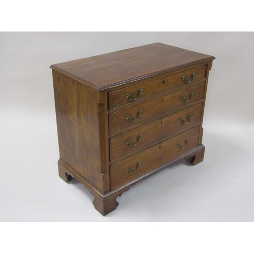 2045 - A George III oak chest of four long graduated drawers with encanted corners, the top with moulded ed... 