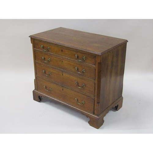 2045 - A George III oak chest of four long graduated drawers with encanted corners, the top with moulded ed... 