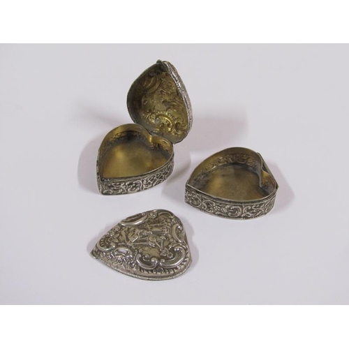 1543 - Two silver heart shaped trinket boxes with embossed decoration, each 5cm w. (one a/f)