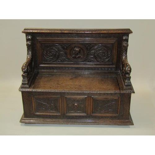 2014 - A Victorian oak box seat, the panel profusely carved with a central warrior flanked by scrolling lea... 