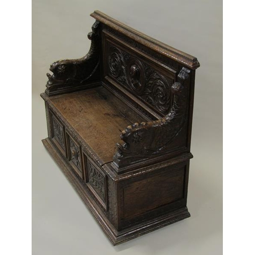 2014 - A Victorian oak box seat, the panel profusely carved with a central warrior flanked by scrolling lea... 