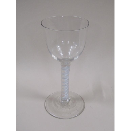 120 - An 18c wine glass with a round funnel bowl on a spiral opaque twist stem, on slightly domed circular... 