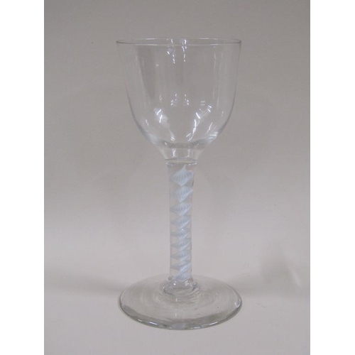 120 - An 18c wine glass with a round funnel bowl on a spiral opaque twist stem, on slightly domed circular... 