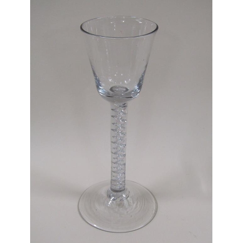 124 - An 18c wine glass with a round funnel bowl on an air twist stem with a circular domed foot, 16.2cm h... 