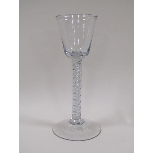 124 - An 18c wine glass with a round funnel bowl on an air twist stem with a circular domed foot, 16.2cm h... 