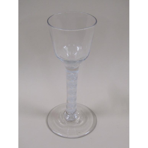 126 - An 18c wine glass with a double series opaque twist stem, a round funnel bowl and slightly domed cir... 