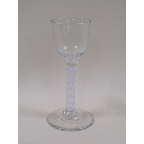 126 - An 18c wine glass with a double series opaque twist stem, a round funnel bowl and slightly domed cir... 