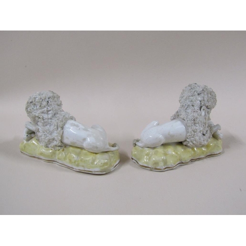 141 - A pair of 19c Staffordshire poodles, each with a bird, painted yellow bases, 7cm h.