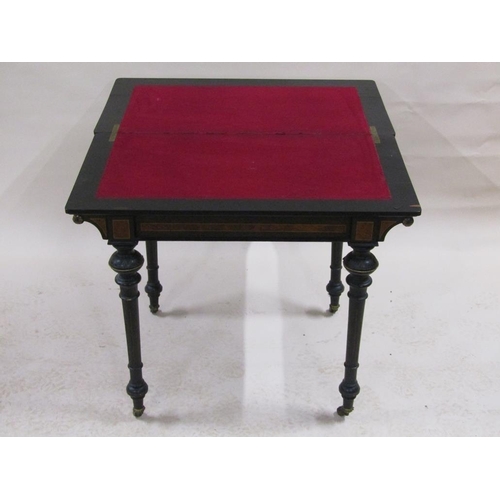 255 - A late Victorian burr walnut and ebonised fold over card table with beaded brass edge mounts, suppor... 