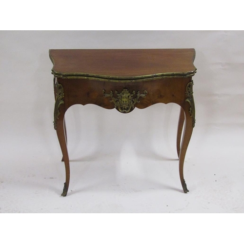 268 - A 19c walnut fold over card table of serpentine form with ormolu mounts and supported on cabriole le... 