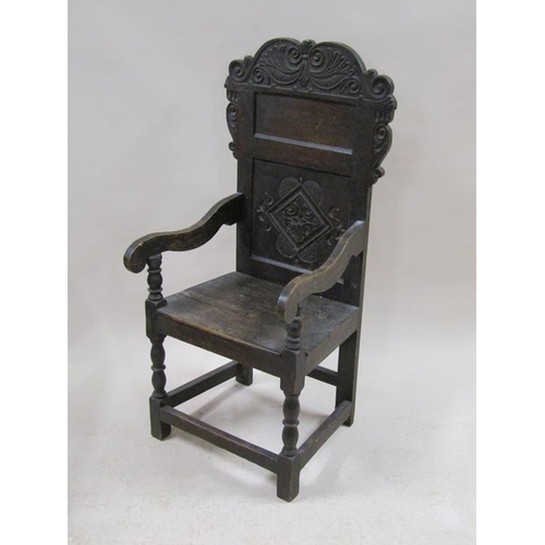 296 - A late 17c/early 18c oak armchair with carved panel back, scrolling arms, supported on baluster ring... 