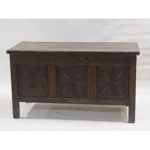 297 - An early 18c oak coffer of large proportion, the front three panels floral carved under an arcaded f... 