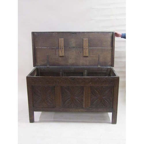 297 - An early 18c oak coffer of large proportion, the front three panels floral carved under an arcaded f... 