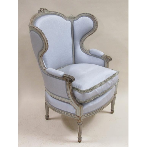 300 - A 19c upholstered wingback armchair with loose squab cushion, having a carved limed show frame.