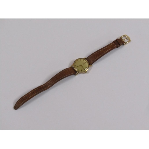 52 - A ladies Omega wristwatch with gold case movement and brown leather strap.