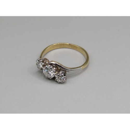 64 - An 18ct gold diamond trilogy crossover ring, central stone 1/2ct, size M.