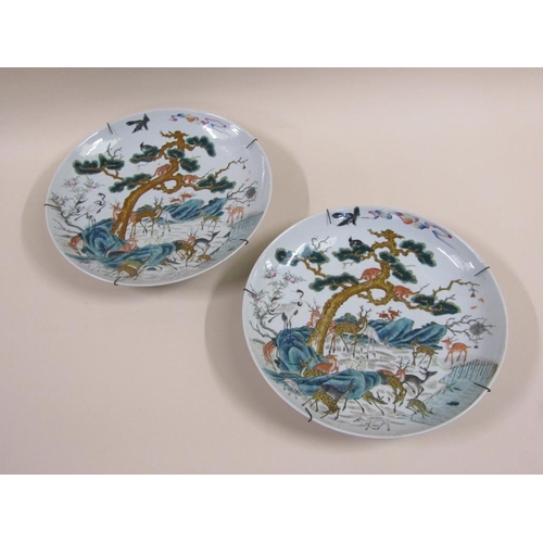 139 - A pair of 19c Chinese famille verte chargers decorated with deer under a pine tree with monkeys and ... 