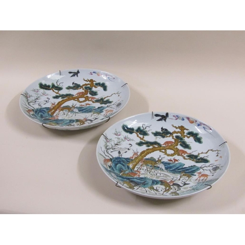 139 - A pair of 19c Chinese famille verte chargers decorated with deer under a pine tree with monkeys and ... 